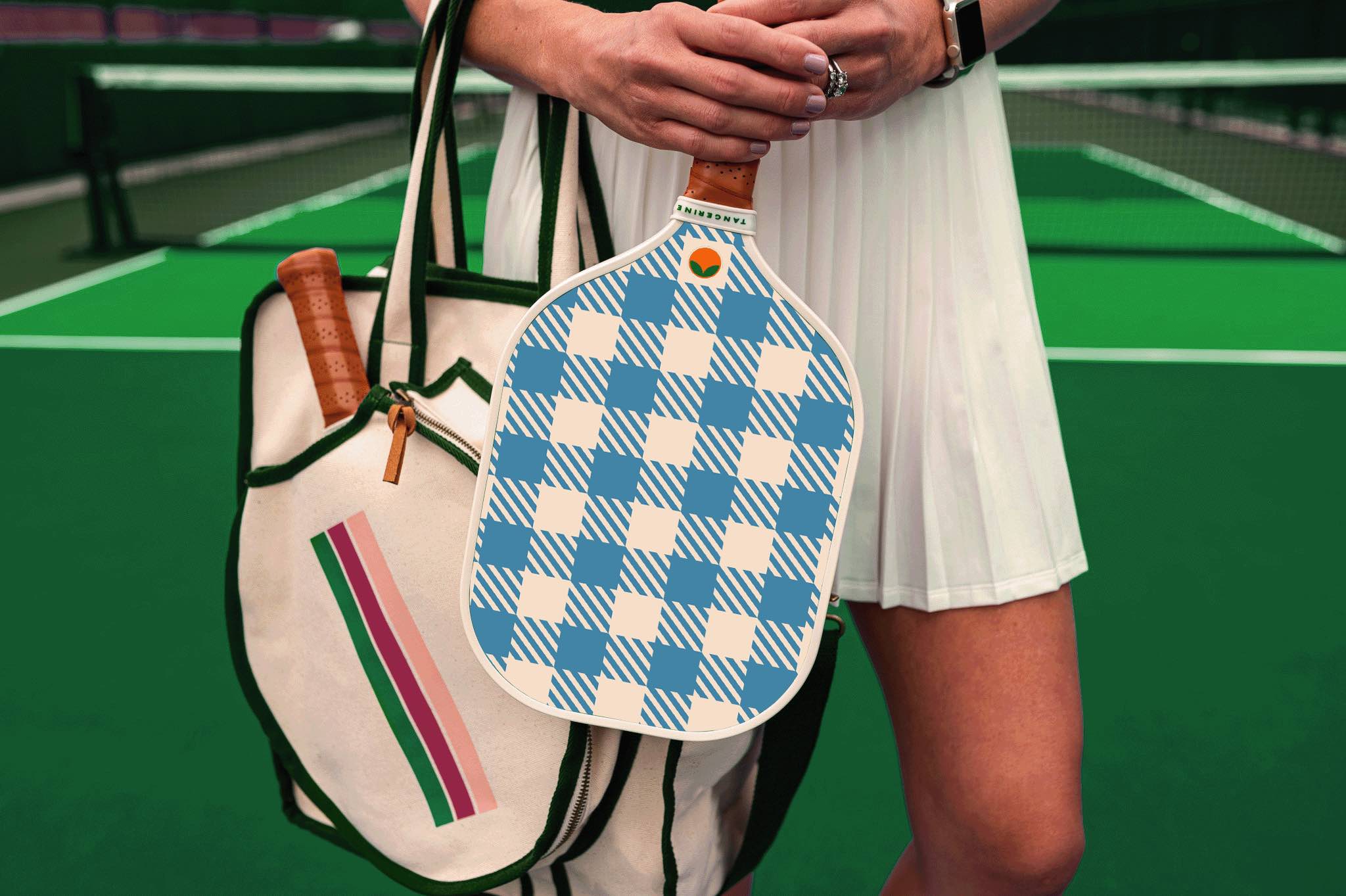 Woman holding blue gingham pickleball paddle