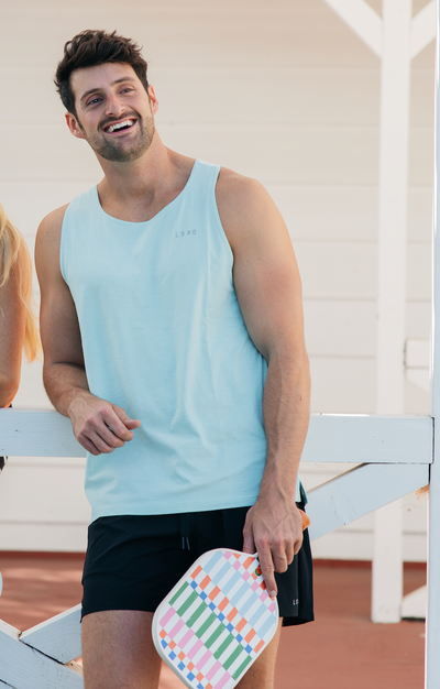 Man holding colorful Napa pickleball paddle by Tangerine. 