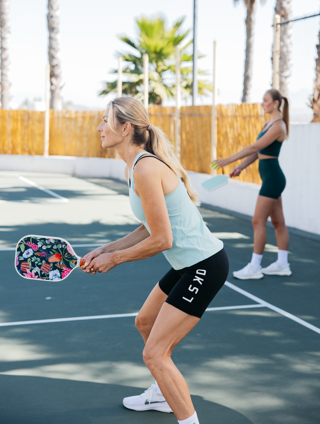 Two women playing pickleball. 