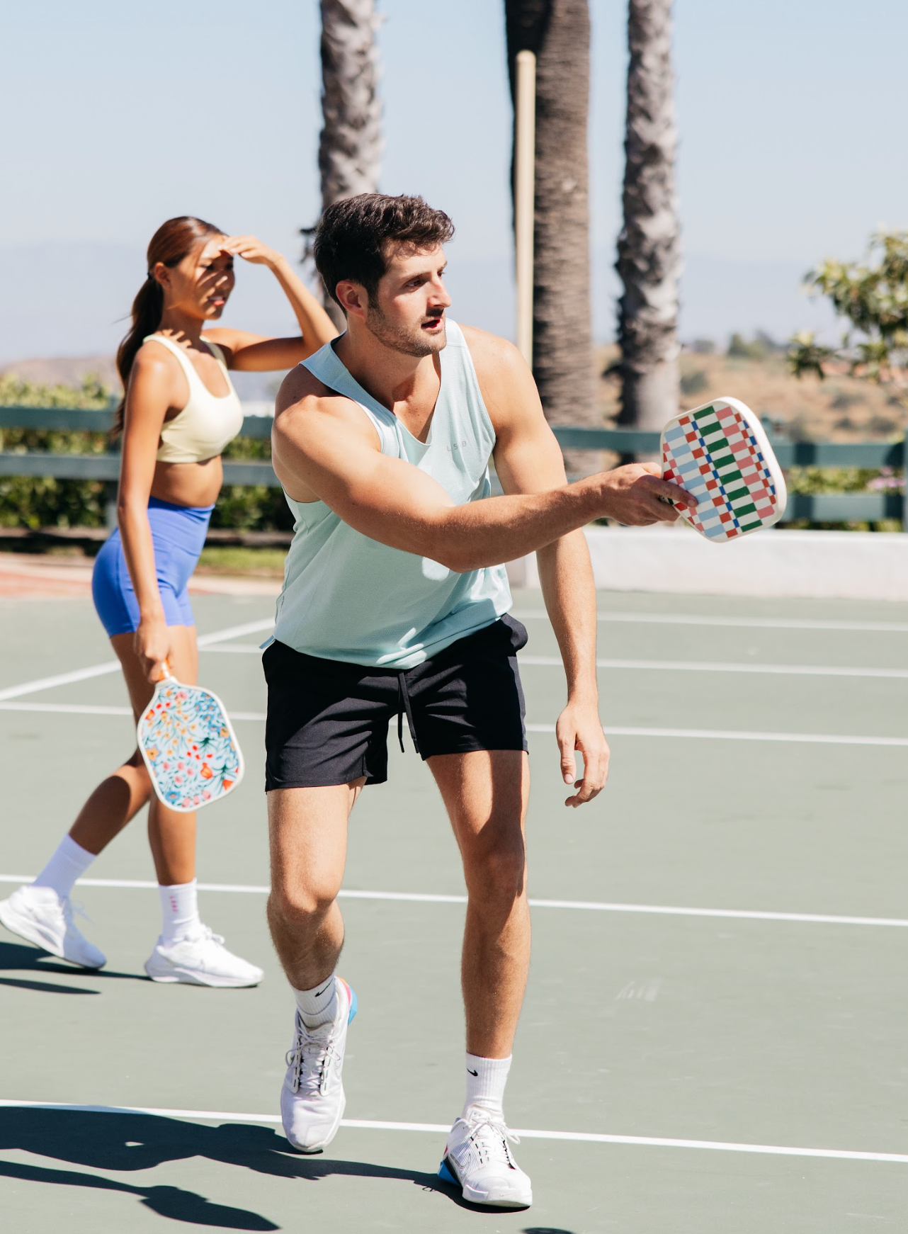 Man playing pickleball with colorful pickleball paddle. 