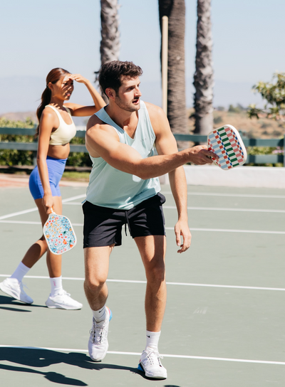 Man playing pickleball with colorful pickleball paddle. 