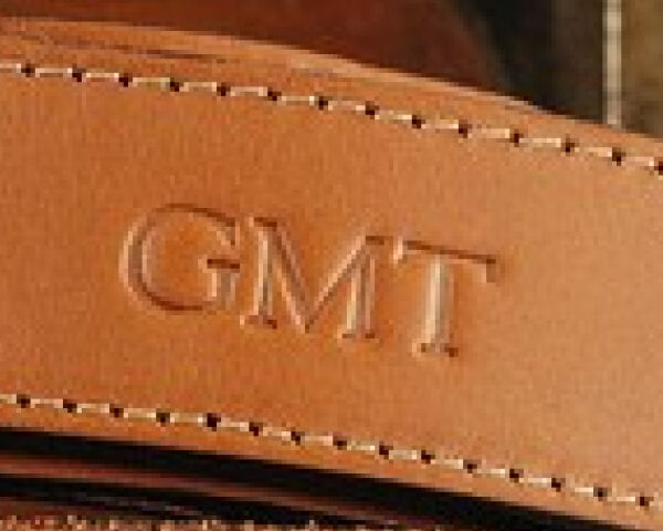 Monogrammed initials on a leather belt tab